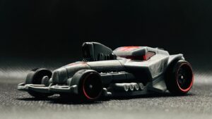 A dark gray toy race car with red accents