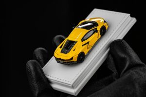 Yellow toy car on stack of white books