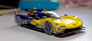 A yellow and blue Cadillac race car model on a white surface